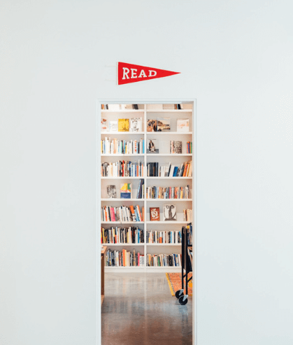 An image of a doorway with bookshelves inside and a red banner above the doorway that says 'read'