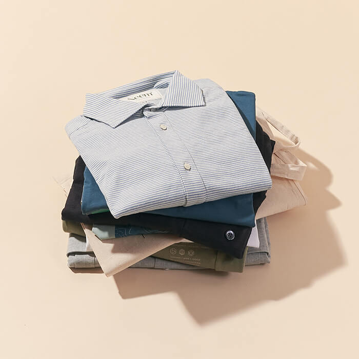 A stack of folded t-shirts and shirts