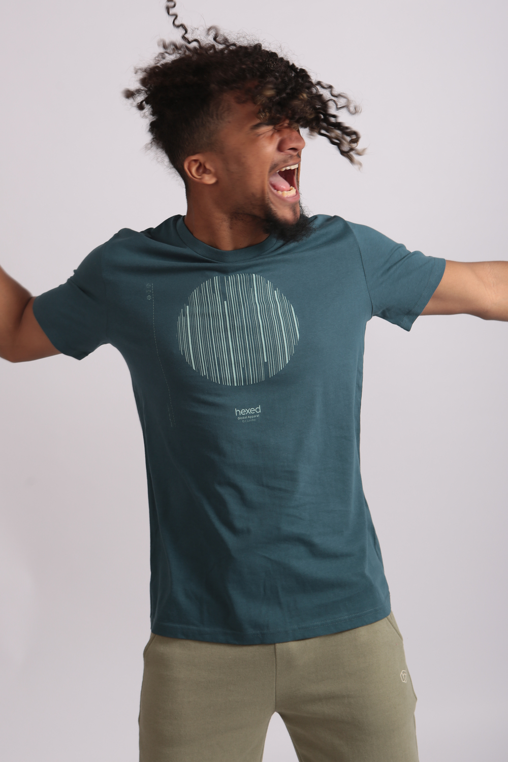 A man jumping, wearing a teal Hexed t-shirt with a printed graphic on it